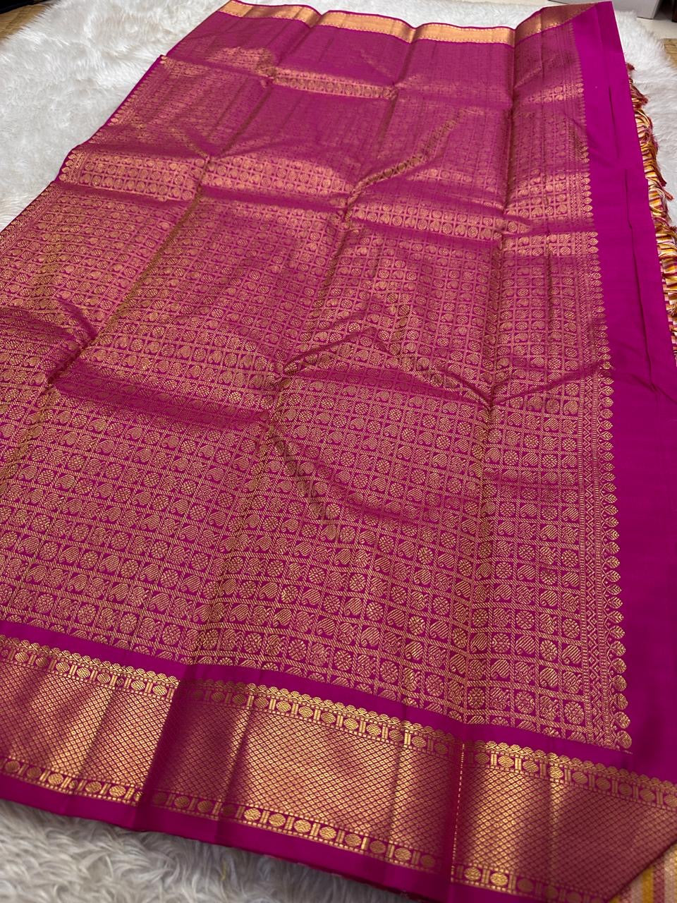 A classic Kanchipuram in Pattani Kattam checks with pink, magenta, mustard, and cream.
Finished with a contrast pink border and pallu.
Paisley and chakram motifs in a graceful grid add timeless charm.