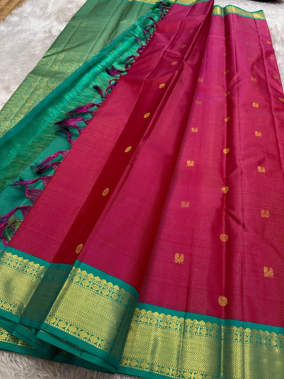 A Very unusual raspberry pink and teal vairaoosi pure silk Kanchipuram Mayil and coin zari buttas all over the boat on top of the zari stripes ! Detailed mayil paisley chakram grid pattern on Pallu 💕