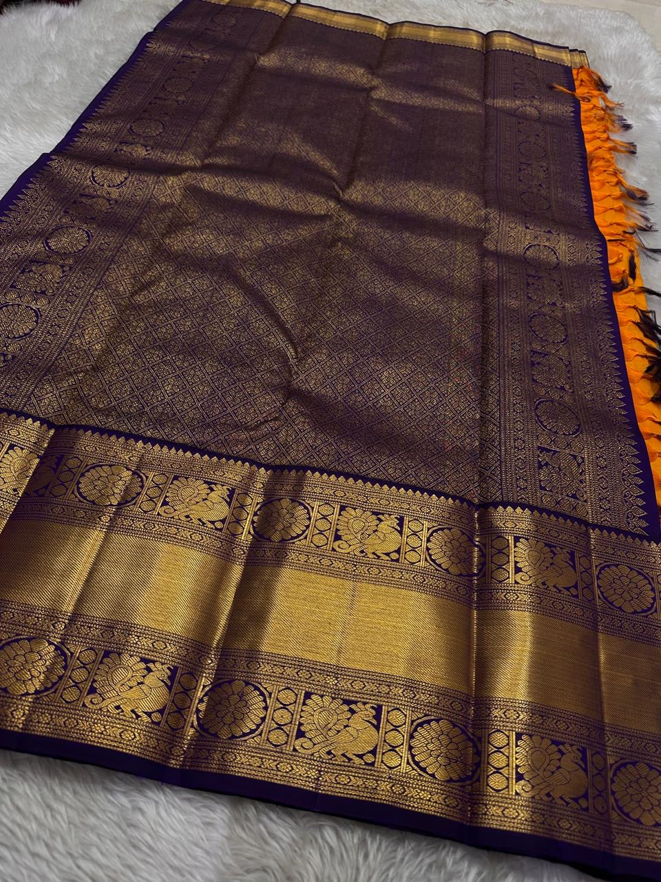 This Maambazha yellow Kanchipuram silk saree features zari mayil buttas and a deep blue rettapet border with kamalam motifs — a timeless blend of tradition and grace.