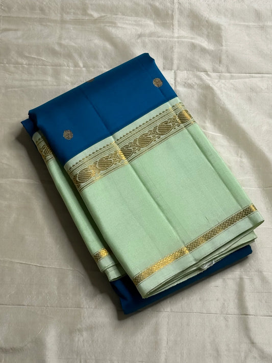 Vasantha Neelam — Teal Korvai Kanchipuram Pure Silk Saree
Peacock-blue body with gold muthu buttas · Mint-pistachio korvai border & pallū
Handloom Kanchipuram • Contrast running blouse included
Silk Mark Certified
Free Shipping within USA, 2 weeks