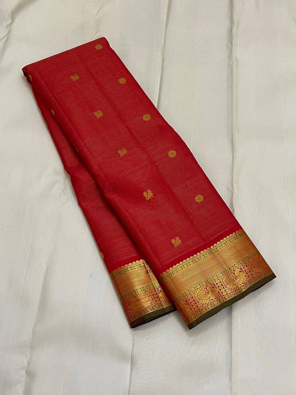 Sringaram Red Vairaoosi – Pure Kanchipuram Silk Saree
Red body with zari coin & floral buttas;
Broad gold border with vairaoosi l & peacock panel; Zari pallu
Silk Mark Certified | Blouse Piece Included | Fall & Pico Done
…read description