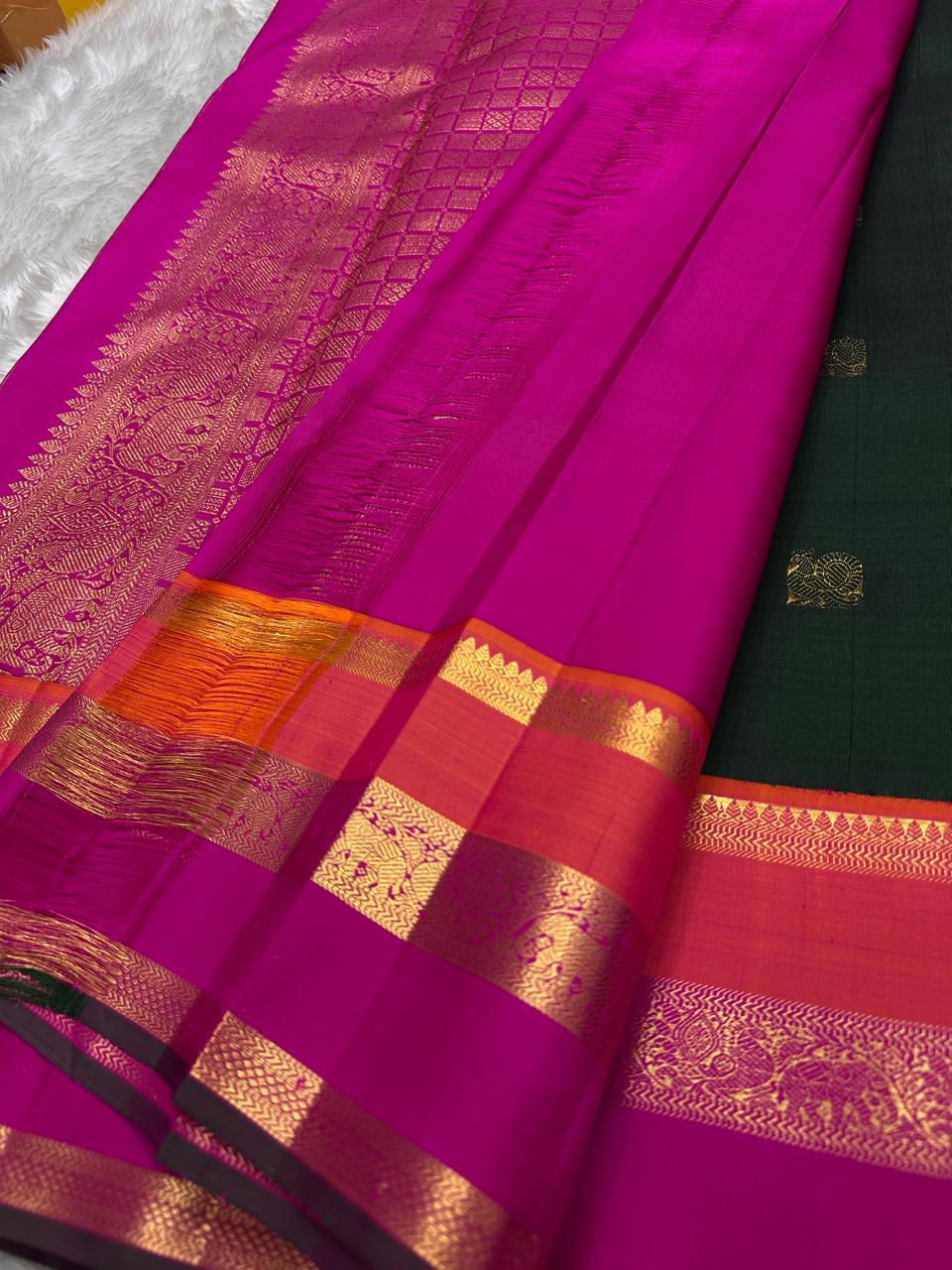 Varna Jaalam Green — Pure Silk Kanchipuram
Bottle-green body with gold chakram & mayil buttas, korvai pink-orange border
Silk Mark Certified • Free USA Shipping • Ships in Two Weeks ✅