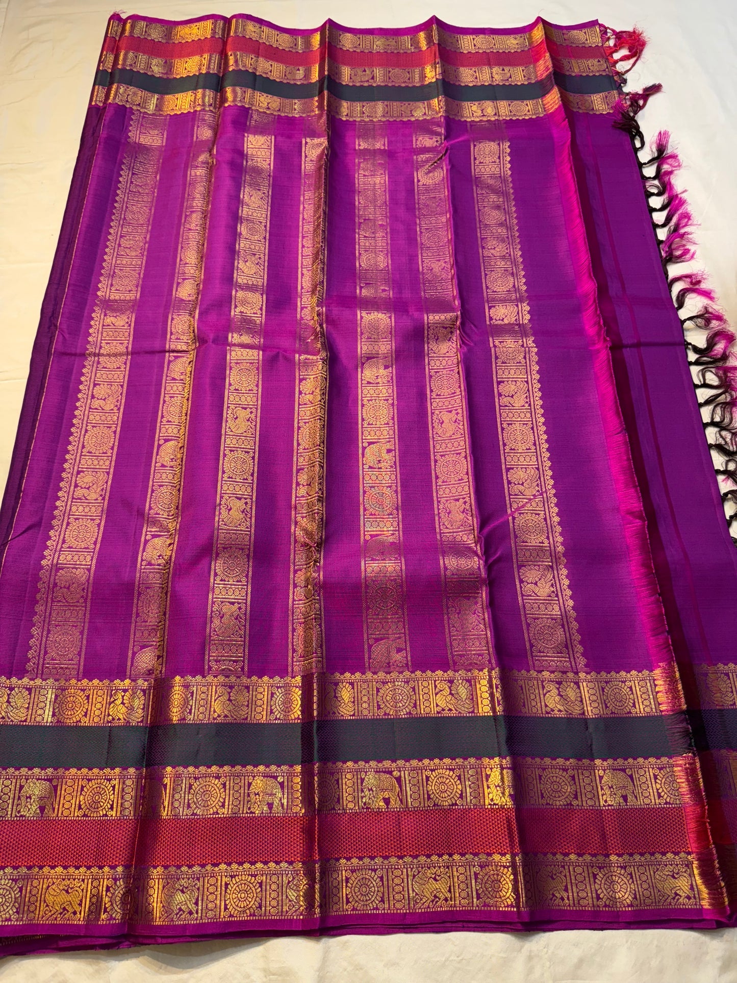 Madhurima — Pure Kanchipuram Silk (Royal Purple × Magenta)
Royal purple body with gold coin buttas, magenta korvai border with zari-woven elephant & peacock panels, and rich magenta pallu.
Silk Mark Certified • Free Shipping within USA • Ships in Two Week