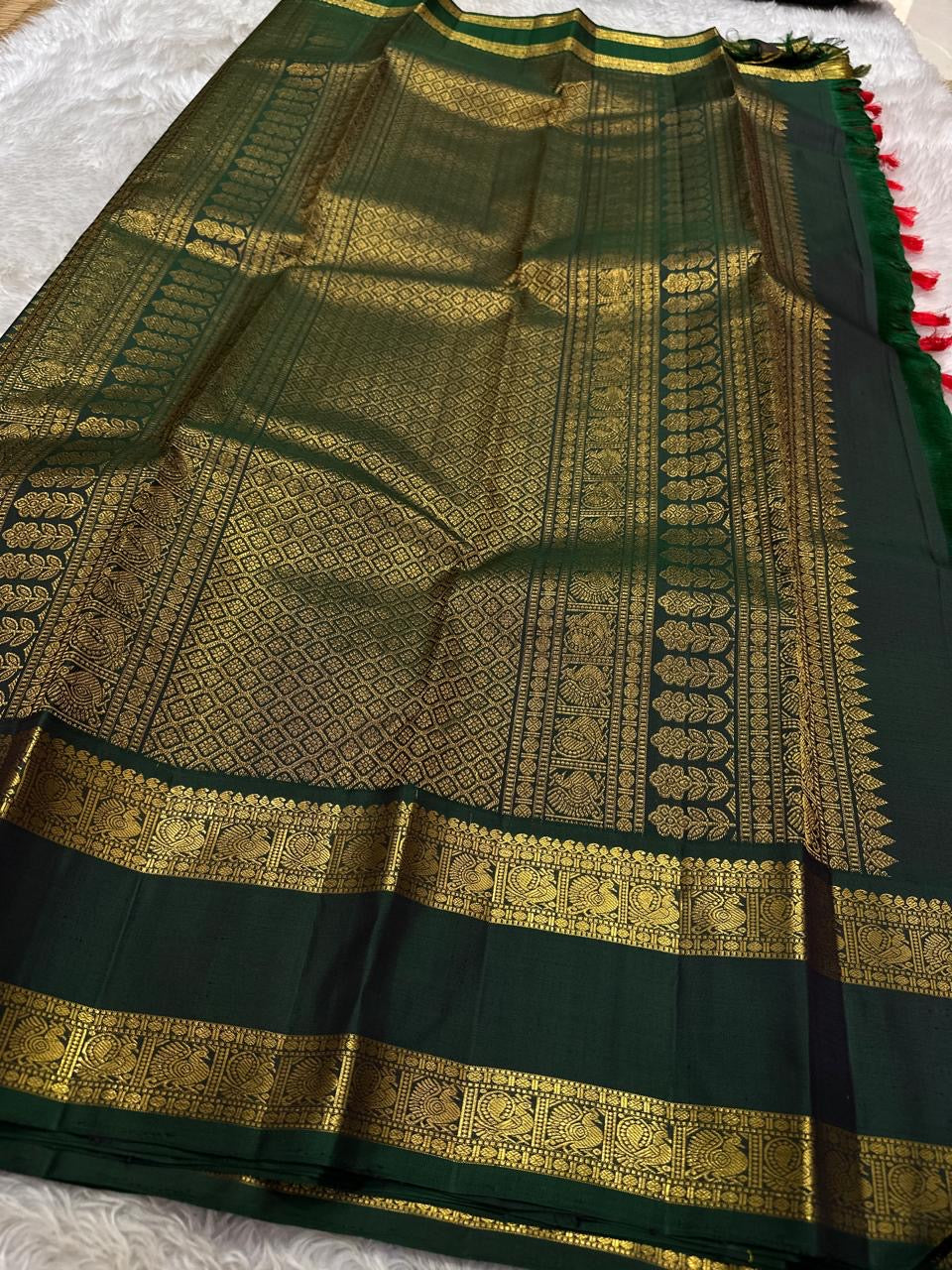Riya – Orange Silk Saree with Dark Green Zari Border
Radiating warmth and festive charm, Riya glows in a rich ombré of orange and vermilion, adorned with dainty gold butta motifs that shimmer gently with movement.