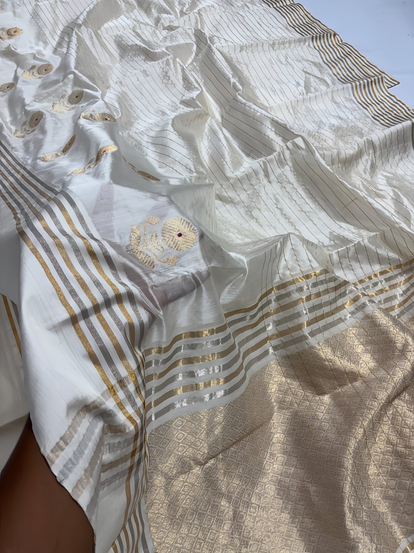 Ivory Cream Chanderi Saree with Gold Zari and Handwoven Sunflower Motifs.
A serene blend of tradition and elegance, with intricate red mina accents. Finished with alternating sona roopa stripes and a richly woven pallu for timeless festive charm