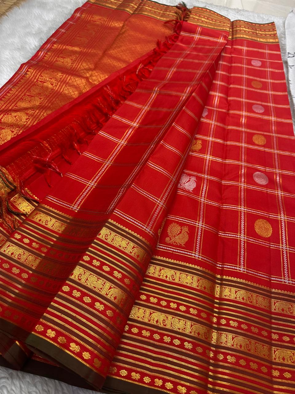 Avanti 🌺 – Vermilion Red Kanchipuram Pure Silk Saree
Gold & Silver Sonaroopa Zari Checks with Buttas
Peacock & Coin Motifs in Classic Elegance
Elephant–Annam Border & Grand Zari Pallu
Silk Mark Certified | Blouse stitching available