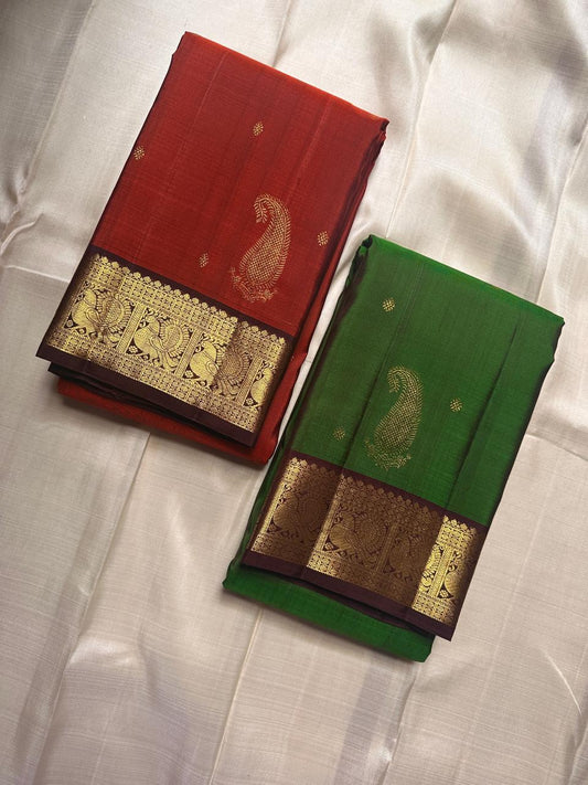 Shringaram – Green — Pure Silk Kanchipuram
Emerald-green body with coin buttas & grand mango (mankolam) motifs
Deep coffee-brown korvai borders with peacock panel zari
Rich coffee-brown brocade pallu with circular & diamond jaal
Silk mark
