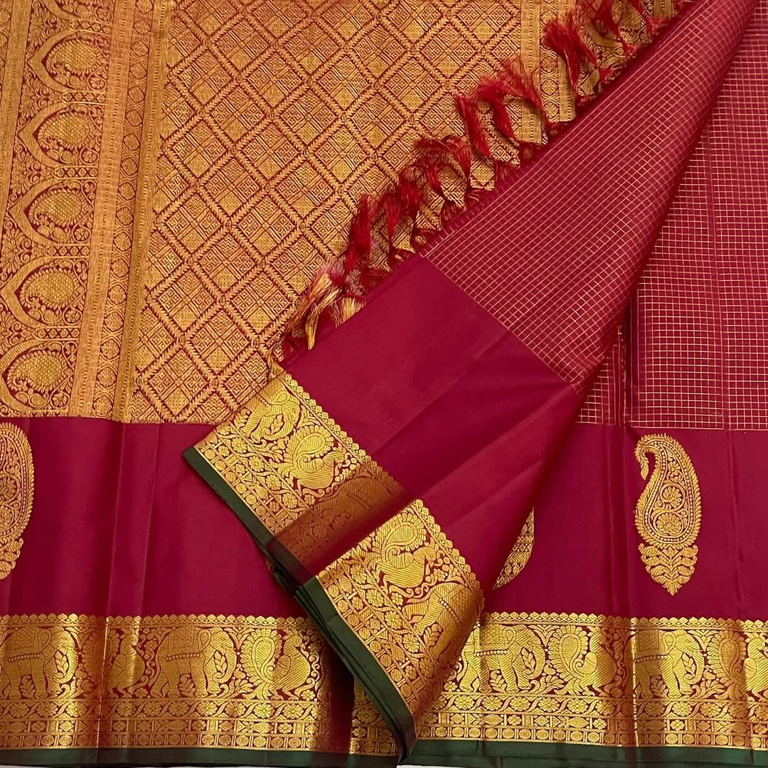 Ushas, Deep Arakku Red Pure Kanchipuram Silk Saree
Radiant Oosi Kattam body with ornate Paisley 2gm Zari
Vanasringaram,Muthuseer,Kamalam border with Fishpettu detailing
Exquisite diamond-pet grid Zari pallu, richly finished with a bold deep green selvedge