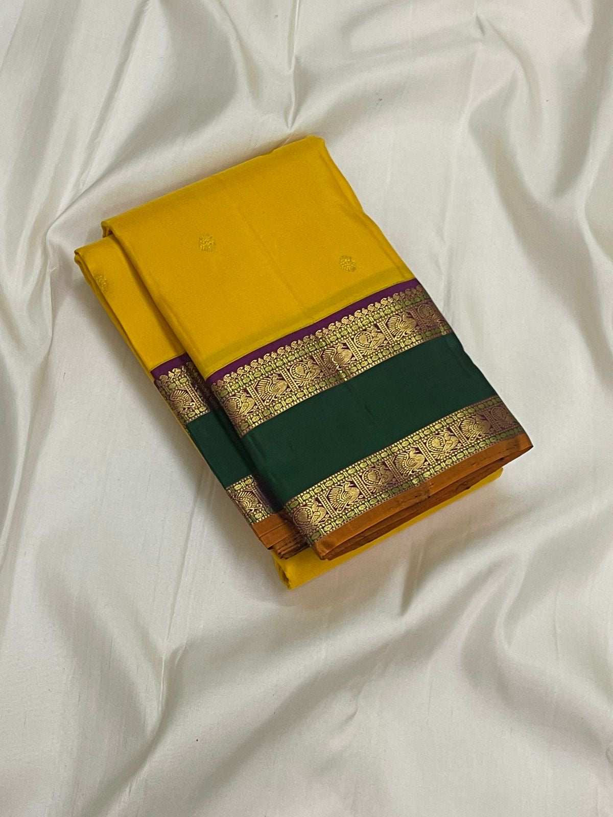 Amrita Pallavi — Kanchipuram Pure Silk
Marigold Yellow Body with Gold Zari Buttas ✨
Deep Bottle-Green Korvai Borders with Paisley Zari & Violet Selvedge
Regal Purple Pallu with Diamond Jaal and Leaf Columns 🌸
Silk Mark Certified | Free USA Shipping |