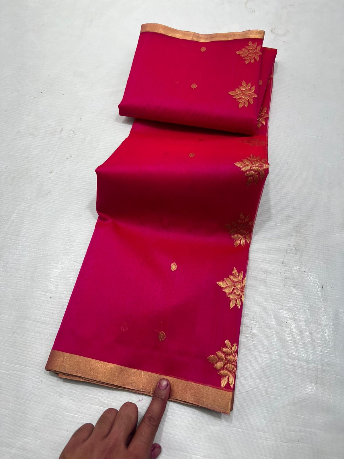 A timeless classic, this Rani pink Chanderi silk saree is a celebration of heritage and elegance. Crafted from lightweight silk with a luxurious sheen, the saree features all-over gold zari floral leafy buttas