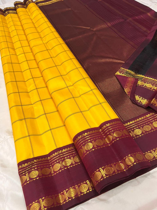 Marigold Yellow & Arakku Pure Silk Kanchipuram Saree
Classic kattam checks across the radiant marigold body
Deep arakku-maroon korvai borders with coin medallion zari
Rich maroon pallu with traditional zari  motifs
Silk Mark Cert • Ships in 2 weeks