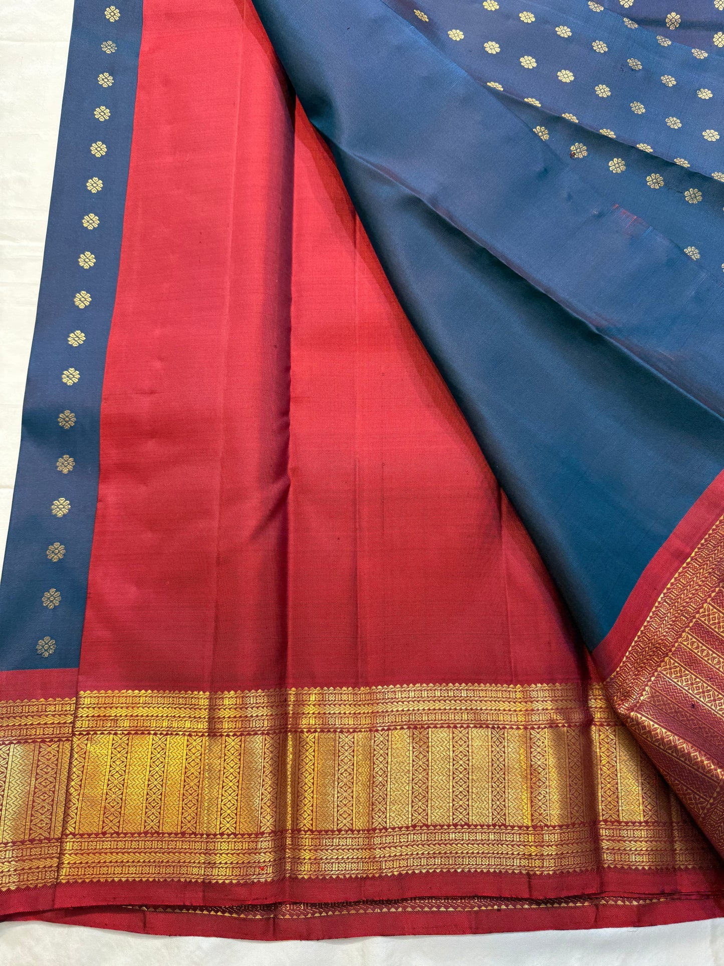 Midnight Neelam Flower Butta — Kanchipuram Pure Silk
Deep midnight neelam (navy) body with scattered gold flower buttas
Korvai contrast maroon borders with grand + geometric zAri motifs 
Rich zari pallū with ornamental motifs; hand-twisted tassels