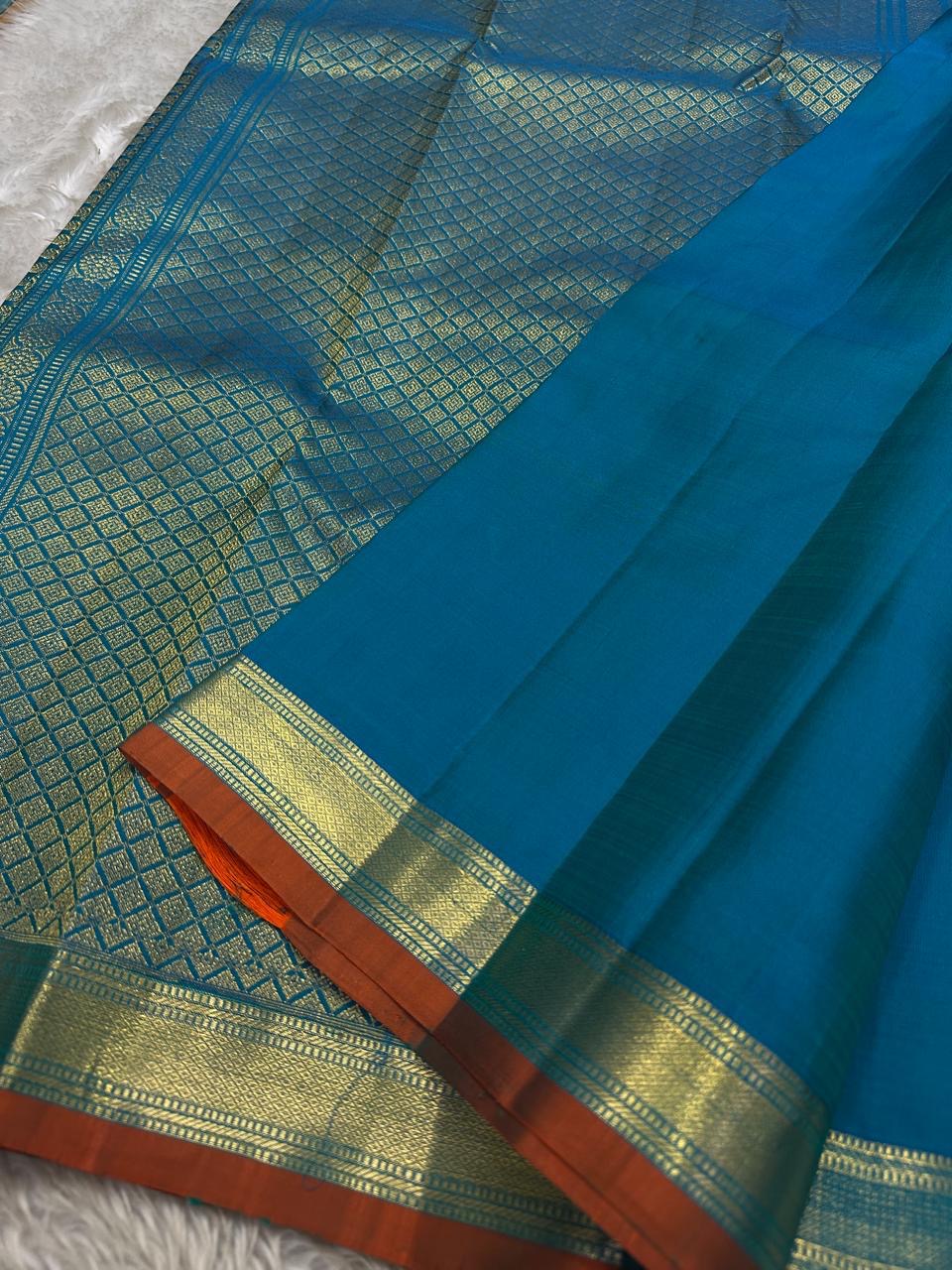 Peacock Teal Ilai Butta – serene teal body with copper-gold zari borders
Pure Kanchipuram silk • dainty leaf (ilai) buttas scattered across the body
Rich teal zari pallu
Silk Mark Certified | Fall & Pico Done | Blouse Stitching Available ($30)