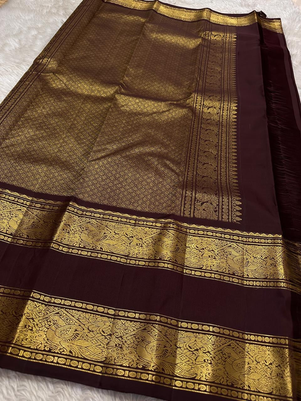 Kasturi 🌰✨
Deep Coffee Brown Pure Silk Kanchipuram Saree
Gold Zari Woven Kamalam & Diamond Buttas All Over
Double Border with Mayil Pettu & Rettapettu Detailing
Diagonal Peacock Pallu with Floral Vine Motifs