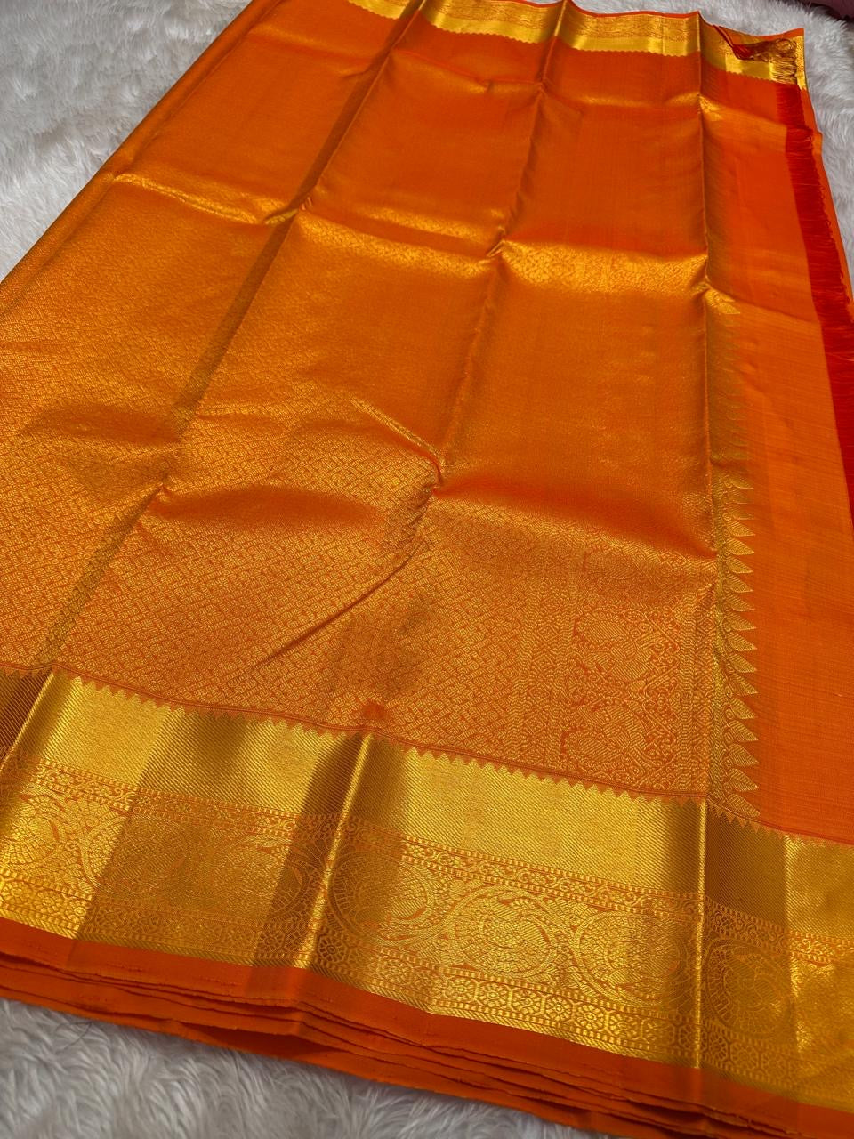 Agnika – orange Kanchipuram Silk Saree with Mayil Chakram Butta & Orange Border Fiery and regal, Agnika is a pure Kanchipuram silk saree featuring a rich red body adorned with intricate Mayil Chakram buttas.