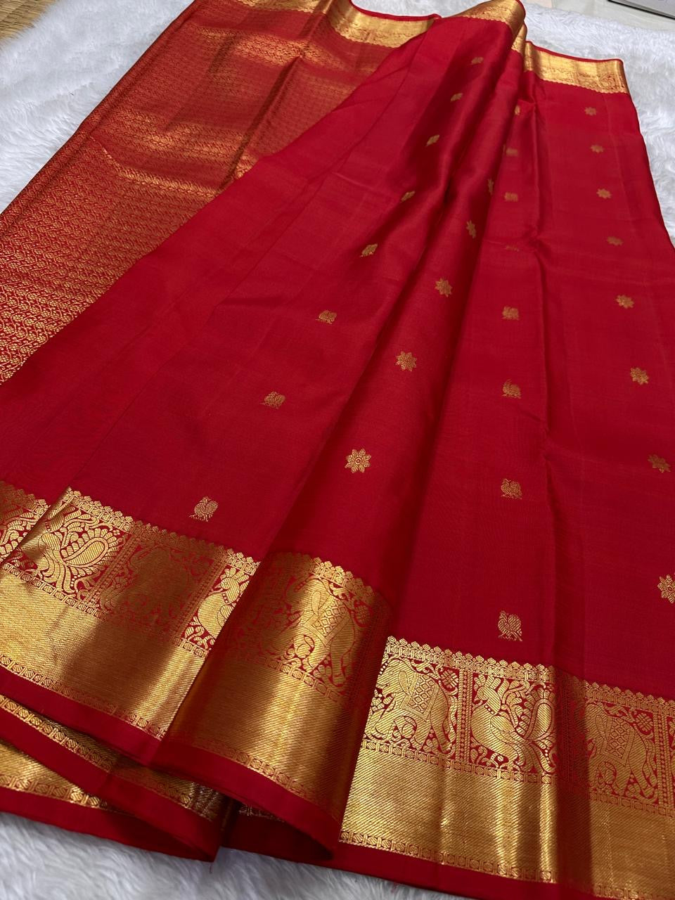 Dia ✨ – Chilli Red Pure Kanchipuram Silk Saree
Allover Gold Zari Floral Buttas on Body
Broad Elephant–Peacock (Gaja–Mayil) Zari Panel Border
Rich Red & Gold Brocade Pallu with Intricate Weaves
Silk Mark Certified | Fall & Pico Done | Blouse Stitching $30