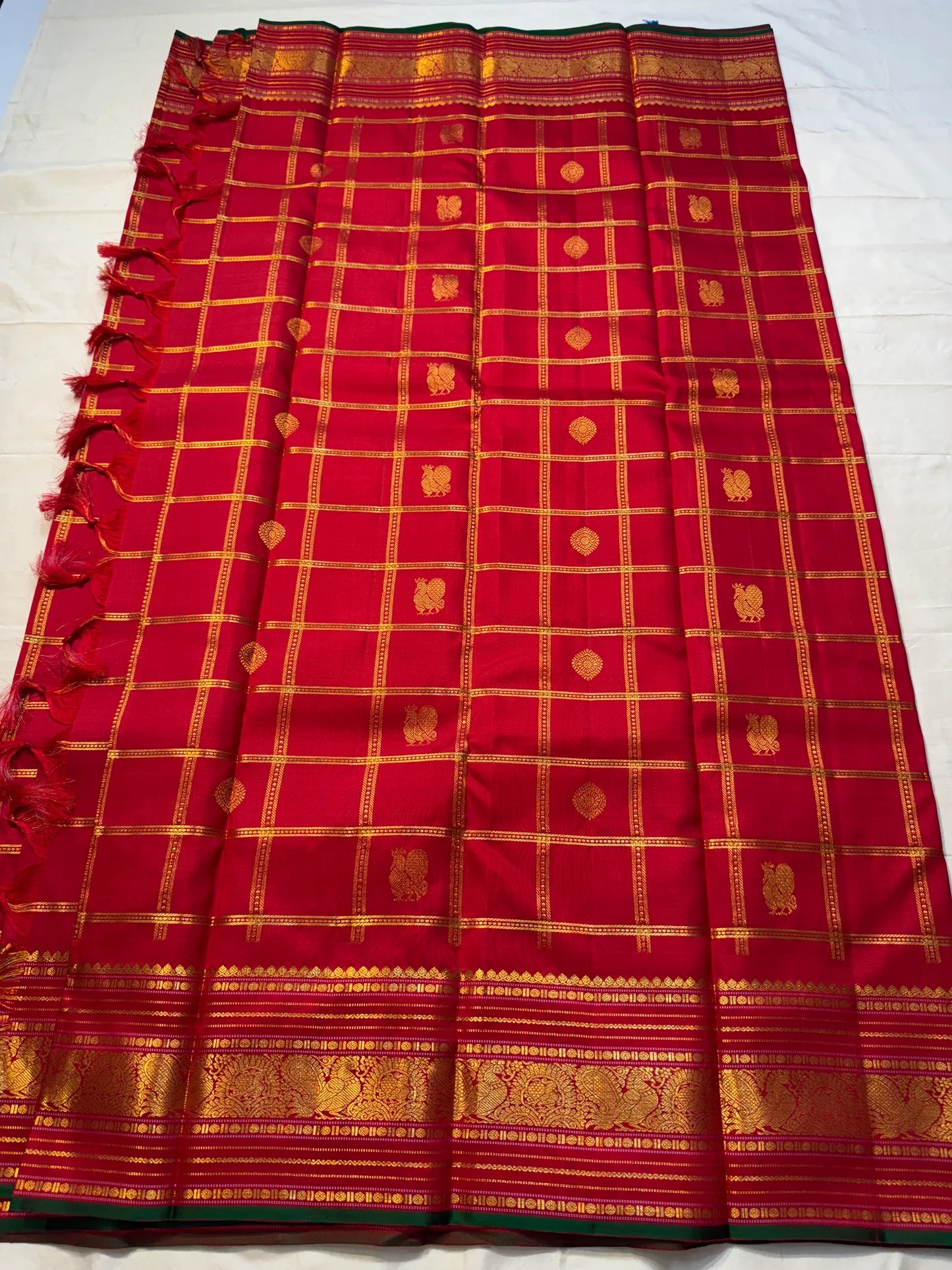 Ravi Kiranam — Sona Roopa Kattam Kanchipuram Pure Silk
Vibrant festive red body with allover kattam (grid) checks
Gold & silver sona-roopa zari alternating for a soft shimmer
Grand kaddi border with rich zari paisley vines & floral tracery
Silk Mark