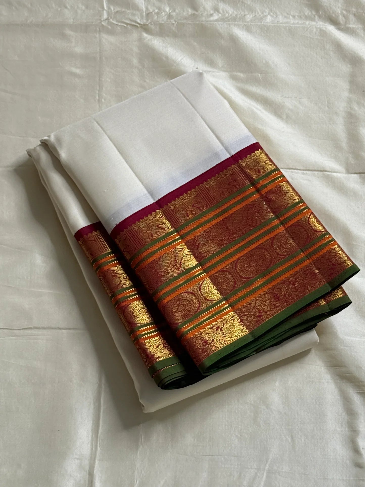 Shveta Chakram — Ivory Kanchipuram Pure Silk 🤍
Contrast maroon brocade pallu & temple border ✨
Chakra medallions, floral vines + green selvedge 🌿
Orange pin-stripes on the border; tasselled finish 🪔
Silk Mark Certified • free shipping with Usa with