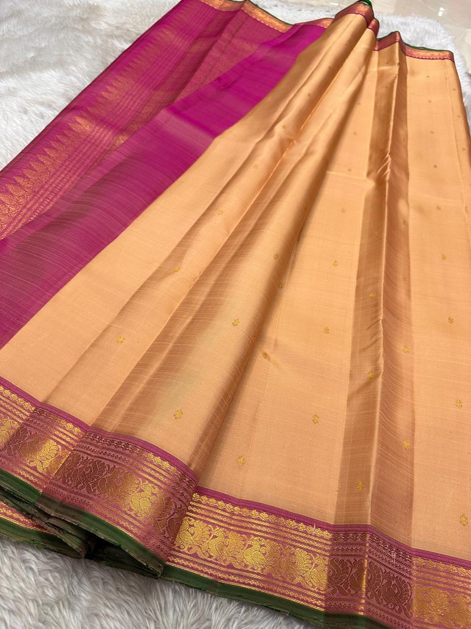 Pure silk kanchipuram Biscuit beige color body with zari buttas , magenta mayil border with green selvedge