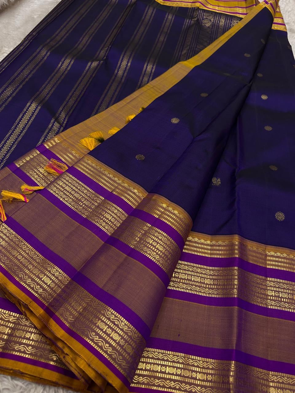 Swarna Laya — Pure Silk Kanchipuram Saree
Deep vaadamalli purple with gold zari buttas, antique-gold border, and rich striped pallu.
Silk Mark Certified • Free USA Shipping • Ships in Two Weeks.