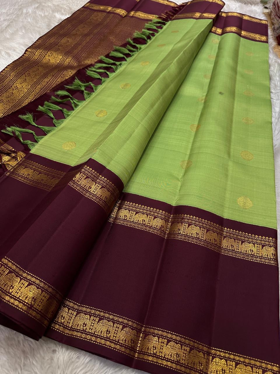 Samprada – Kanchipuram Silk Saree in vibrant cardamom Green & brown
A vibrant parrot green body meets a rich maroon border in this timeless Kanchipuram silk saree