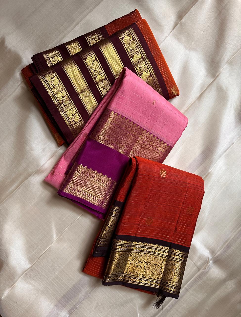 Amber Plume – Pure Kanchipuram Silk Saree
Amber Burnt-Orange Body with Vaira Oosi Stripes
Rudhraksham & Mayil Zari Woven Buttas All Over
Contrast Coffee-Brown Border with Peacock Motif Panel
Silk Mark Certified, delivery in 2 weeks
