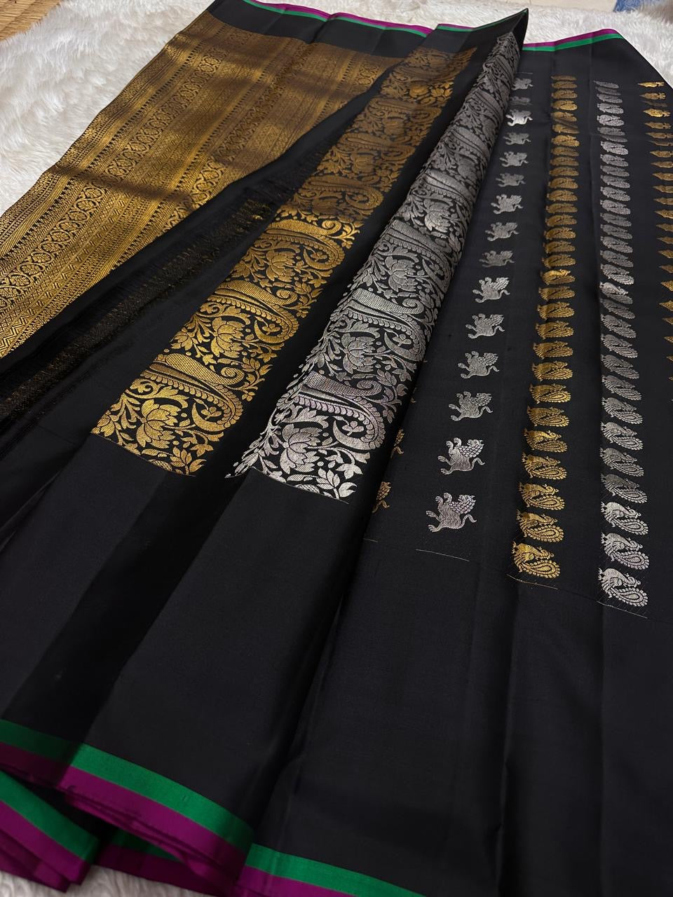 Lavanya – Black Handwoven Kanchipuram Silk Saree with Gold & Silver Zari
A timeless black Kanchipuram silk saree with intricate gold and silver zari motifs — Gandaberunda, parrots, elephants, and lotuses — exuding regal elegance.