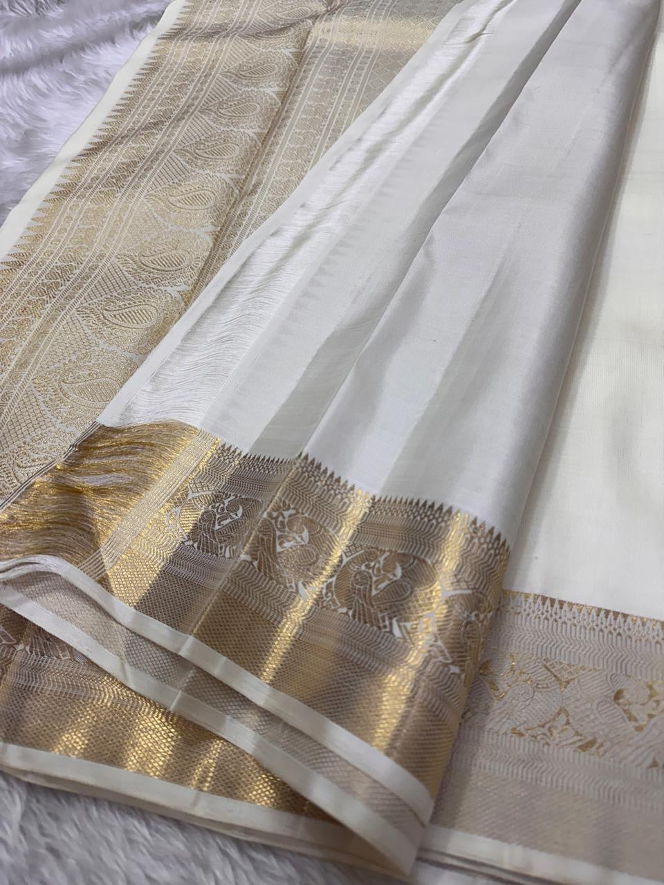 Pearl Radiance ✨ – Pure Kanchipuram Silk Saree
Ivory Body with Gold Zari Buttas & Medallions
Traditional Yali & Peacock Motif Zari Border
Grand Zari Pallu with Paisleys & Floral Vines
Silk Mark Certified | Free USA Shipping