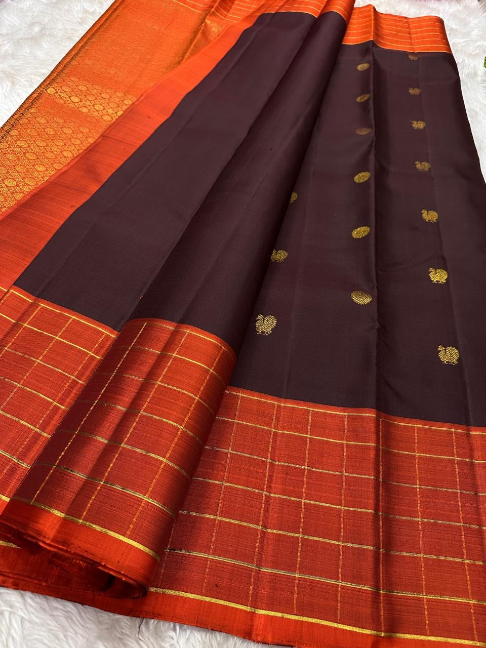 Minmini – Deep brown Pure Kanchipuram Silk Saree with Gold Zari Buttas, Vibrant Orange Checked Border in Zari Kattam Weave & Ornate Gold Brocade Pallu with Traditional Motifs