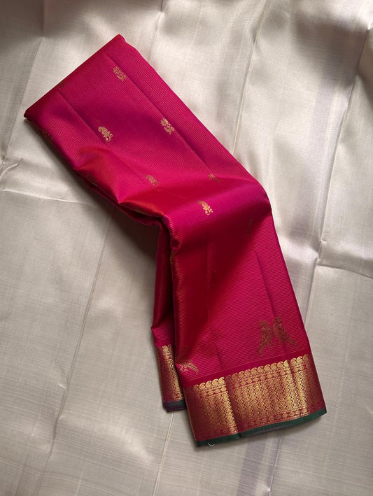 Rani Kili Butta Vairaoosi — Pure Silk Kanchipuram Saree
Rani-pink body with zari buttas & twin parrot motifs, antique-gold coin borders with emerald selvedge
Rich red-orange vairaoosi pallu with rosette brocade, matching blouse included
Silk Mark Cert