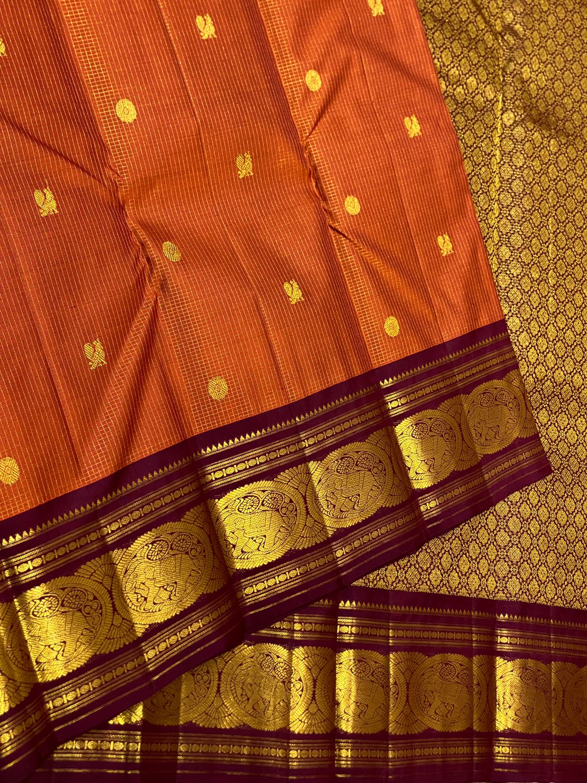 Uma 🌺 – Rust-Orange Kanchipuram Pure Silk Saree
Wide Deep Aubergine-Brown Borders with Sorgavasal Yaanai (Temple Elephant) Motifs
Rich Gold Brocade Pallu with Diamond pettu& Floral Vines