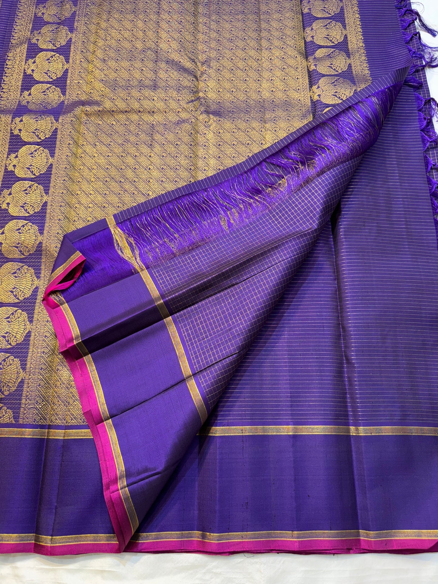Vadamalli Gandaberunda Kattam — Pure Silk Kanchipuram Saree
Royal purple body with fine kattam checks & zari mankolam buttas, adorned with grand Gandaberunda borders and rich diamond brocade pallu with pink selvedge.
Silk Mark Certified ✅ | Fall & Pico