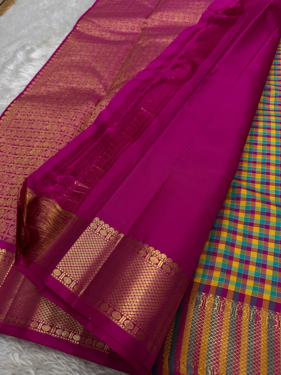 A classic Kanchipuram in Pattani Kattam checks with green, magenta, mustard, and cream.
Finished with a contrast pink border and pallu.
Paisley and chakram motifs in a graceful grid add timeless charm.