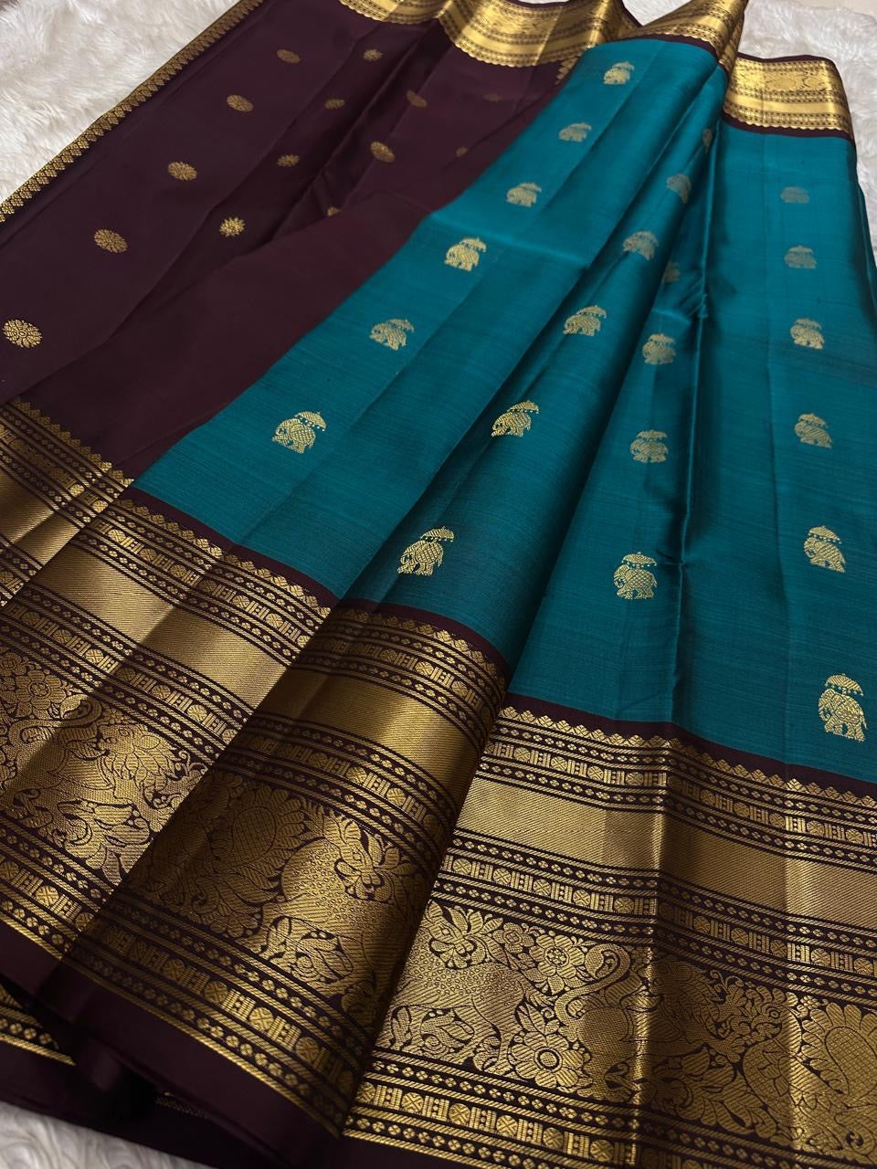 Neeli Megham – Pure Silk Kanchipuram
Teal-blue body with gold annapakshi buttas & aubergine korvai border in antique zari brocade
Silk Mark Certified • Fall & Pico Done • Blouse Stitching Available ($30) • Free Shipping within USA • Ships in Two Weeks