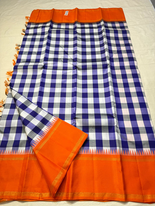 Lilac Indigo Kattam — Pure Silk Kanchipuram Saree
Bold indigo–lilac–white checks with tangerine korvai borders & gold temple edging
Silk Mark Certified • Free USA Shipping • Ships in Two Weeks