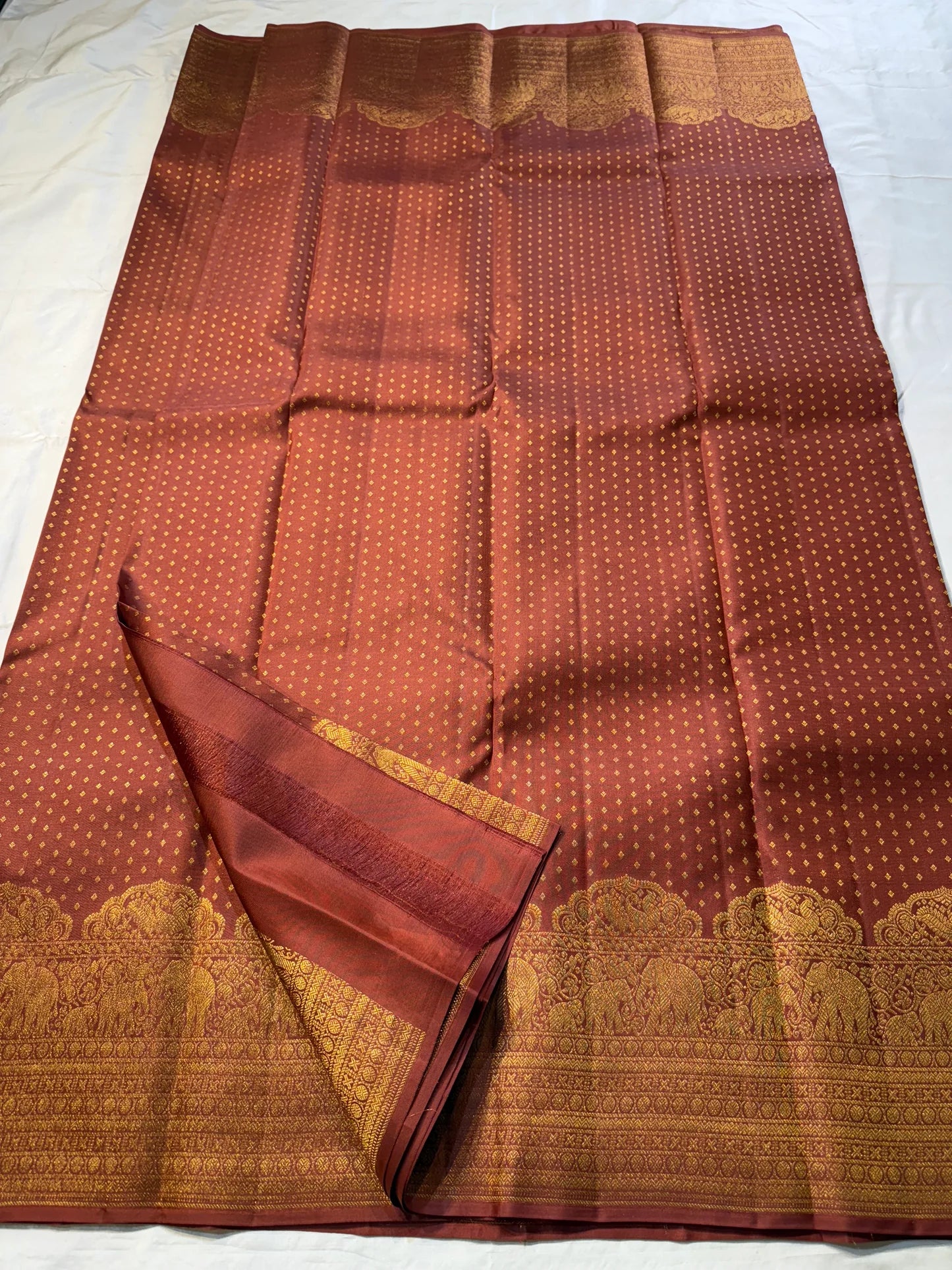 Rust Orange Elephant Peacock Arches – Pure Silk Kanchipuram Saree
Tiny gold podi butta motifs with grand elephant & peacock arch borders
Rich antique-gold zari pallu with floral columns & temple designs
Silk Mark Certified | Free Shipping within USA-