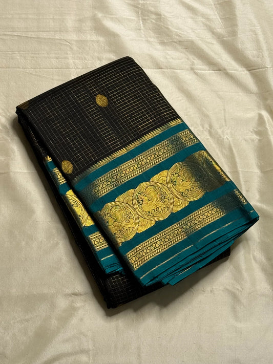 Karuppu Pakshi Kattam – Pure Korvai Kanchipuram Silk Saree
Charcoal black podi kattam body with coin-gold buttas
Peacock-teal korvai border & pallu with pakshi medallion zari
Silk Mark Certified | Blouse Piece Included | Fall & Pico Done
Free Shipping