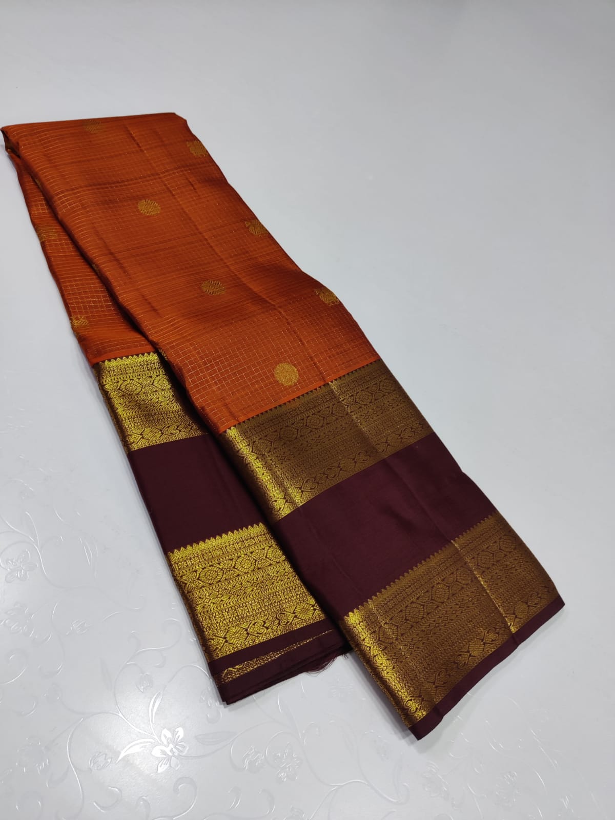Burnt orange pavun butta – Pure Kanchipuram Silk Saree
Burnt Orange body adorned with delicate kattam checks ✨
Scattered gold medallion buttas add timeless temple elegance
Silk Mark Certified, delivery in 2 weeks