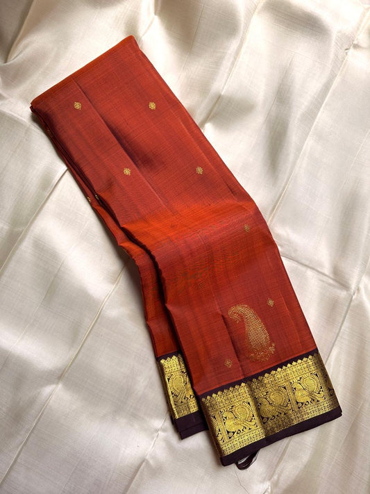 Rust Orange Paisley — Pure Silk Kanchipuram Saree
Rust-orange body with gold coin buttas & grand paisley motif, deep coffee borders with peacock zari panels & temple edge.
Rich zari pallu, contrast blouse; Silk Mark Certified ✅ Free USA Shipping 🇺🇸 Ship