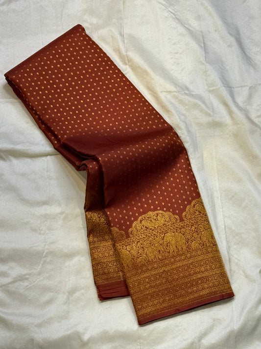 Rust Orange Elephant Peacock Arches – Pure Silk Kanchipuram Saree
Tiny gold podi butta motifs with grand elephant & peacock arch borders
Rich antique-gold zari pallu with floral columns & temple designs
Silk Mark Certified | Free Shipping within USA-