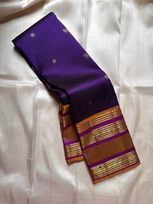 Swarna Laya — Pure Silk Kanchipuram Saree
Deep vaadamalli purple with gold zari buttas, antique-gold border, and rich striped pallu.
Silk Mark Certified • Free USA Shipping • Ships in Two Weeks.