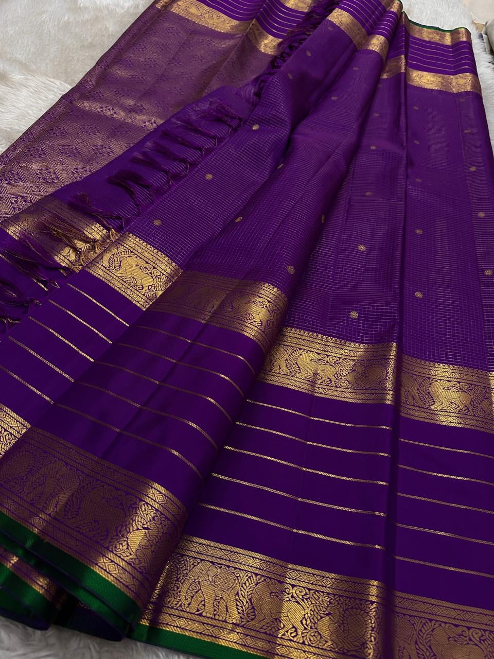 Kiran ✨ – Pure Kanchipuram Silk Saree
Regal Purple Body with Zari Kattam & Buttas
Classic Rettapet Border in Gold Zari Stripes
Intricate Heirloom-Inspired Zari Pallu
Accented with Contrast Green Selvedge Silk Mark Certified, delivery in 2 weeks