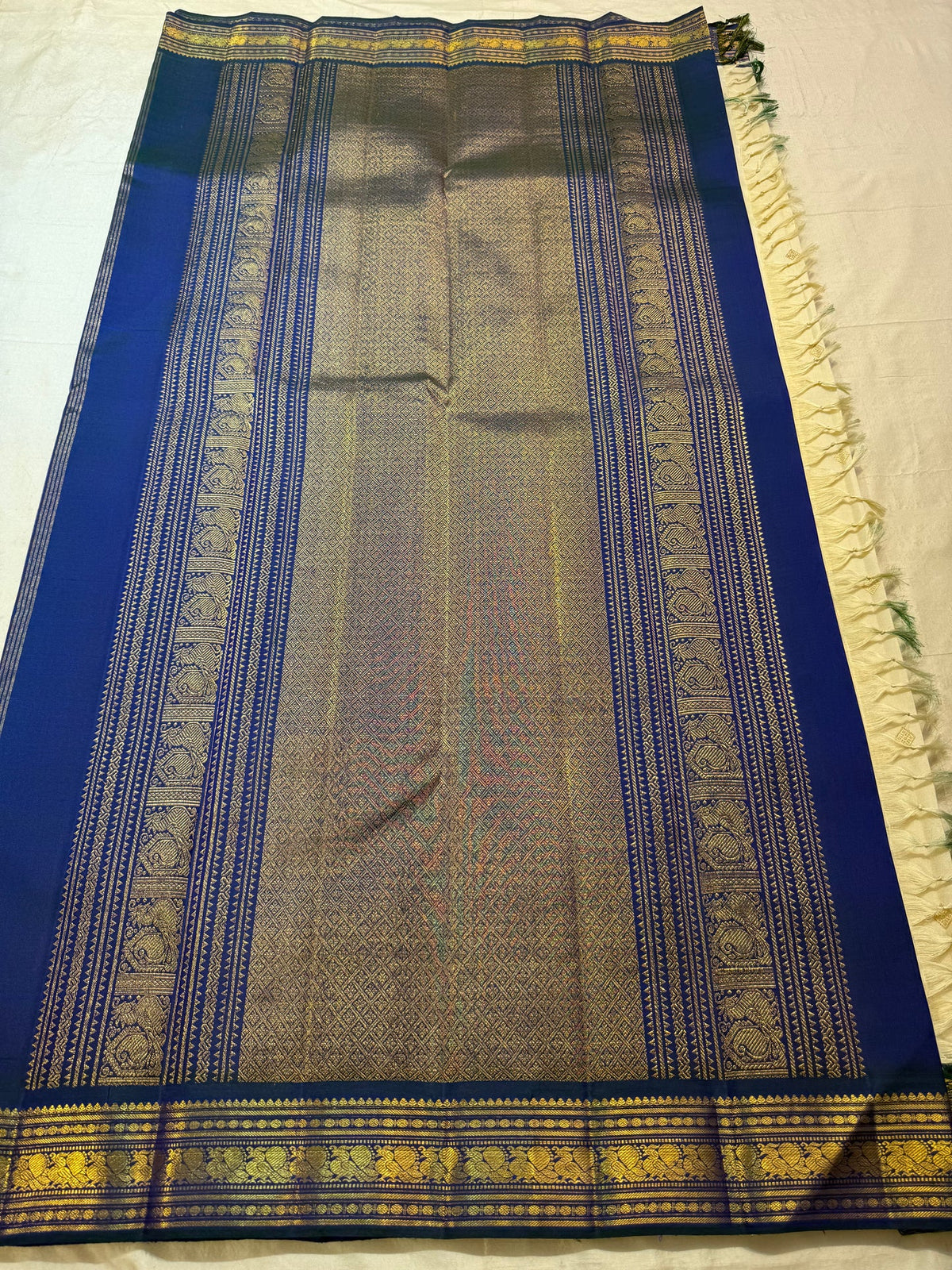 Warm Ivory Handwoven Pure Silk Kanjivaram Korvai saree draped, showing the Mayil Kazhuthu blue-green border and richly woven pallu.