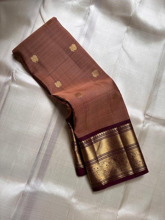 Biscuit Brown Glow – Korvai Kanchipuram Pure Silk Saree
Biscuit-brown (rust shot) body with gold chakram & paisley buttas
Rich deep-brown korvai border with annam medallions & diamond mesh
Grand deep-brown zari pallu |… read description
