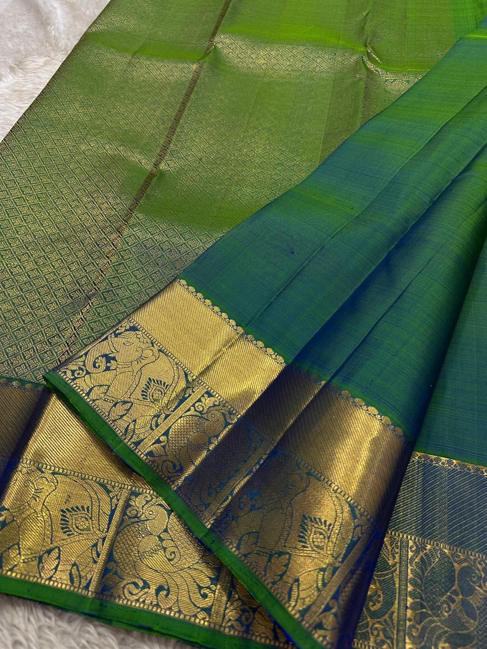 Dia ✨ – Vibrant Peacock Green Kanchipuram Pure Silk Saree
Gold Zari Buttas Adorning the Body
Intricate Gaja–Annam (Elephant & Peacock) Motif Border
Coordinated Peacock Green Silk Blouse Piece Included
Silk Mark Certified | Fall & Pico Done | Ready to Ship