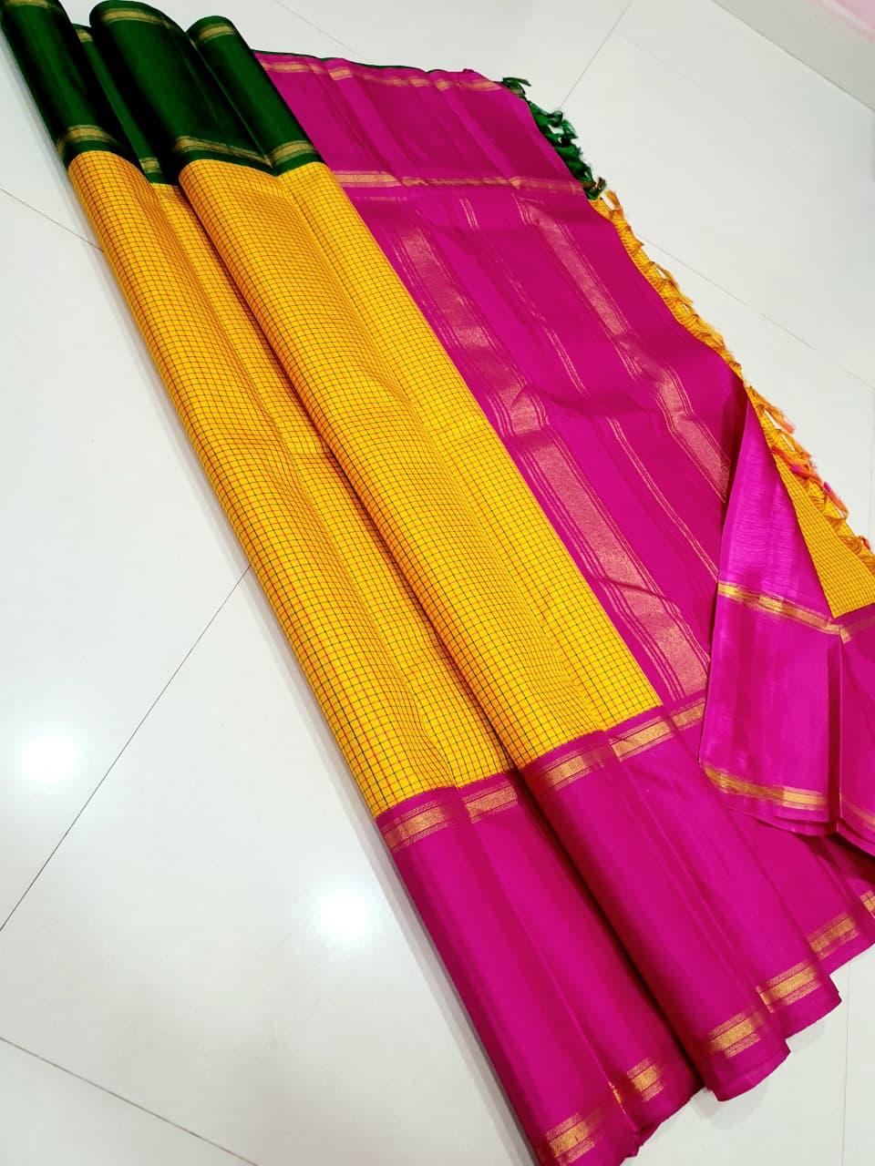 Swarna Kattam Ganga Jamuna — Pure Silk Kanchipuram Saree
Golden mustard kattam checks body • Dual korvai borders in rani pink & emerald green
Rich zari pallu with radiant festive sheen
Contrast emerald blouse with zari selai finish
Silk Mark Certified •