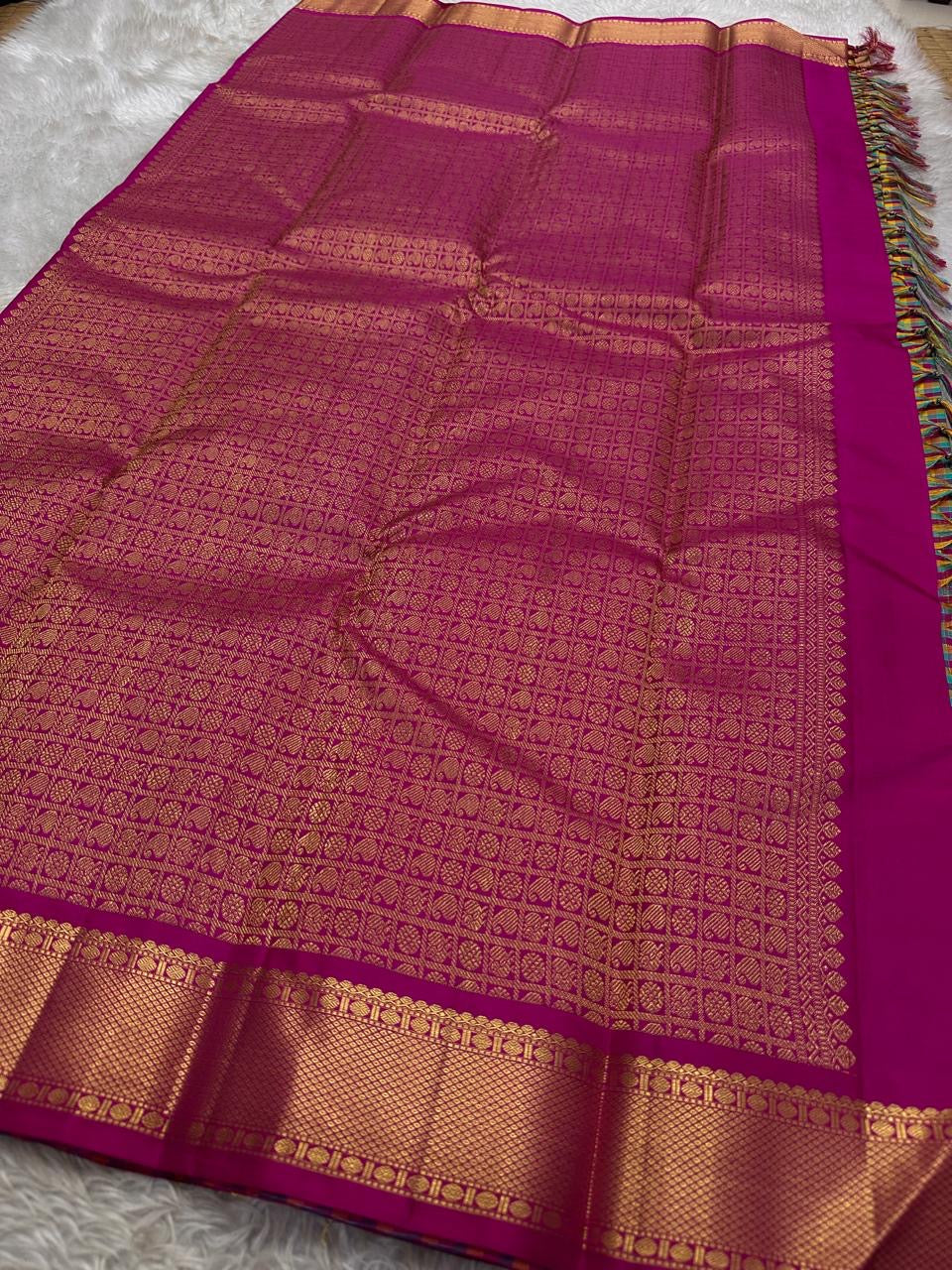 A classic Kanchipuram in Pattani Kattam checks with green, magenta, mustard, and cream.
Finished with a contrast pink border and pallu.
Paisley and chakram motifs in a graceful grid add timeless charm.