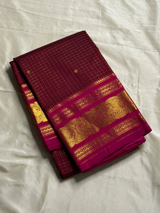 Arakku Kattam Mayura Chakram – Pure Silk Kanchipuram Saree (Maroon & Rani Pink)
Micro-check body with tiny gold buttas; vibrant rani contrast
Antique-gold peacock chakram border & grand woven zari pallu
Silk Mark Certified | Blouse Piece Included |