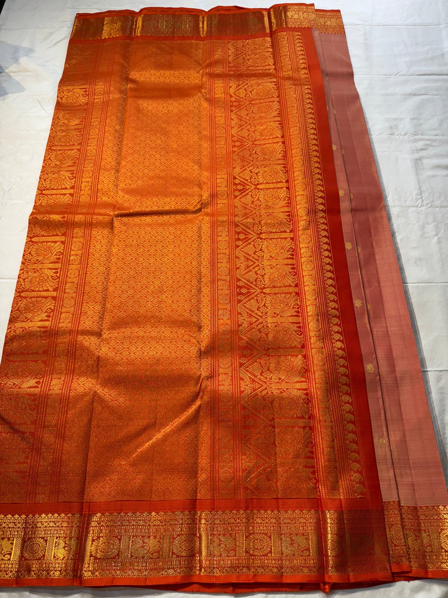 Mandara Peach – Pure Korvai Kanchipuram Silk Saree
Soft peach shot body with dainty gold chakram buttas
Vermilion-orange korvai borders with peacock medallions
Grand kumkumam red pallu with full zari brocade & temple panels
Silk Mark Certified | Free Ship