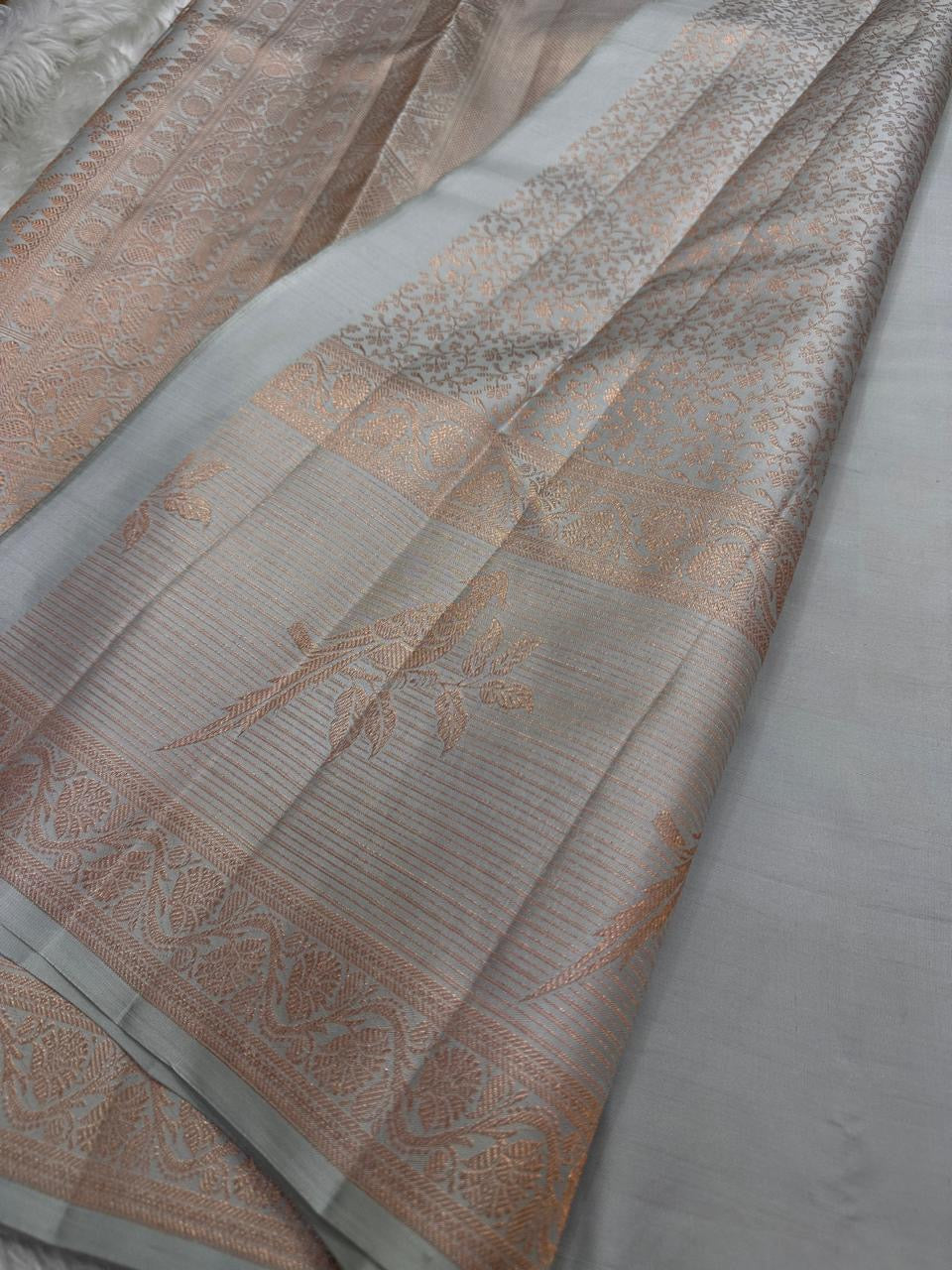 Pakshee 🕊️ – Elegant Kanjivaram Silk Saree
Delicate Ice-Grey Body with Ornate Pakshi Border
Intricate Handloom Detailing & Pure Silk Finish
Celebrate Heritage in Style & Grace